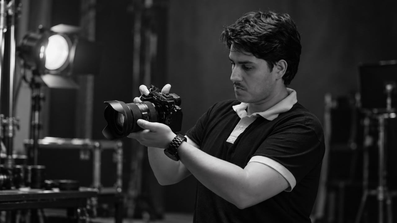 Sonny ajustando sua câmera em estúdio, em fotografia preto e branco